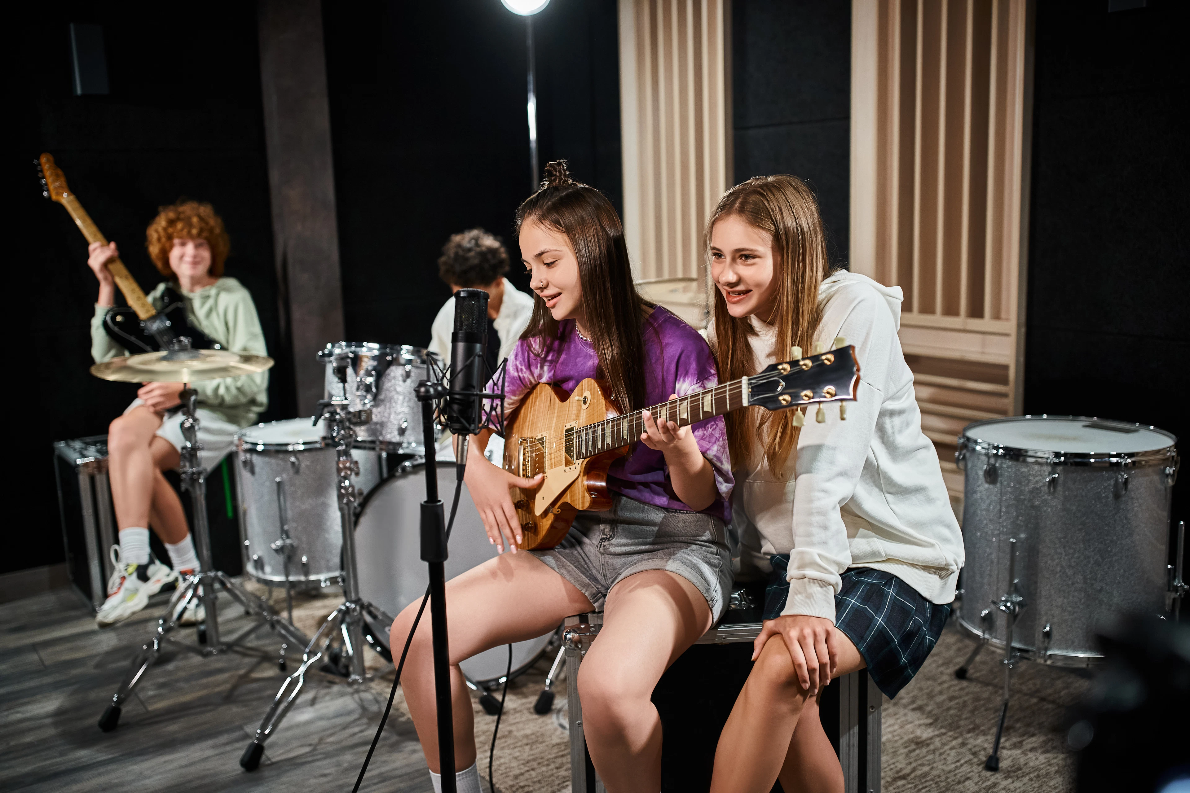 Kids playing instruments together in a rock band class