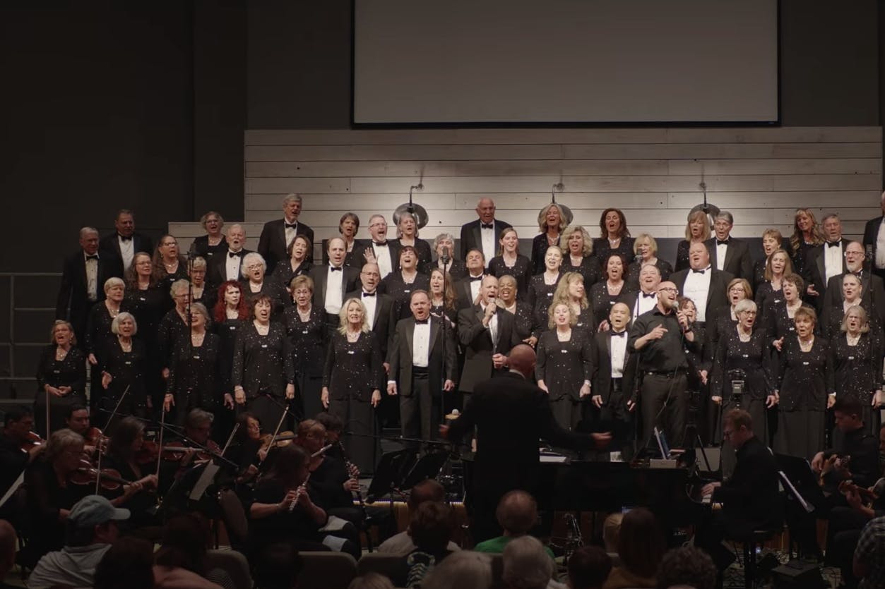 choir performing on stage with white background