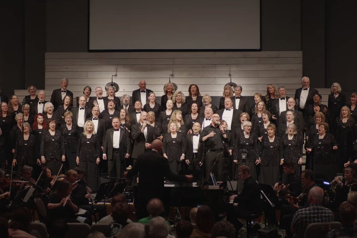 choir performing on stage with white background