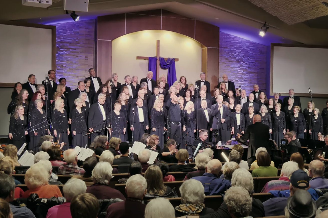 Mosaic performs at a church with a cross in the back of the stage