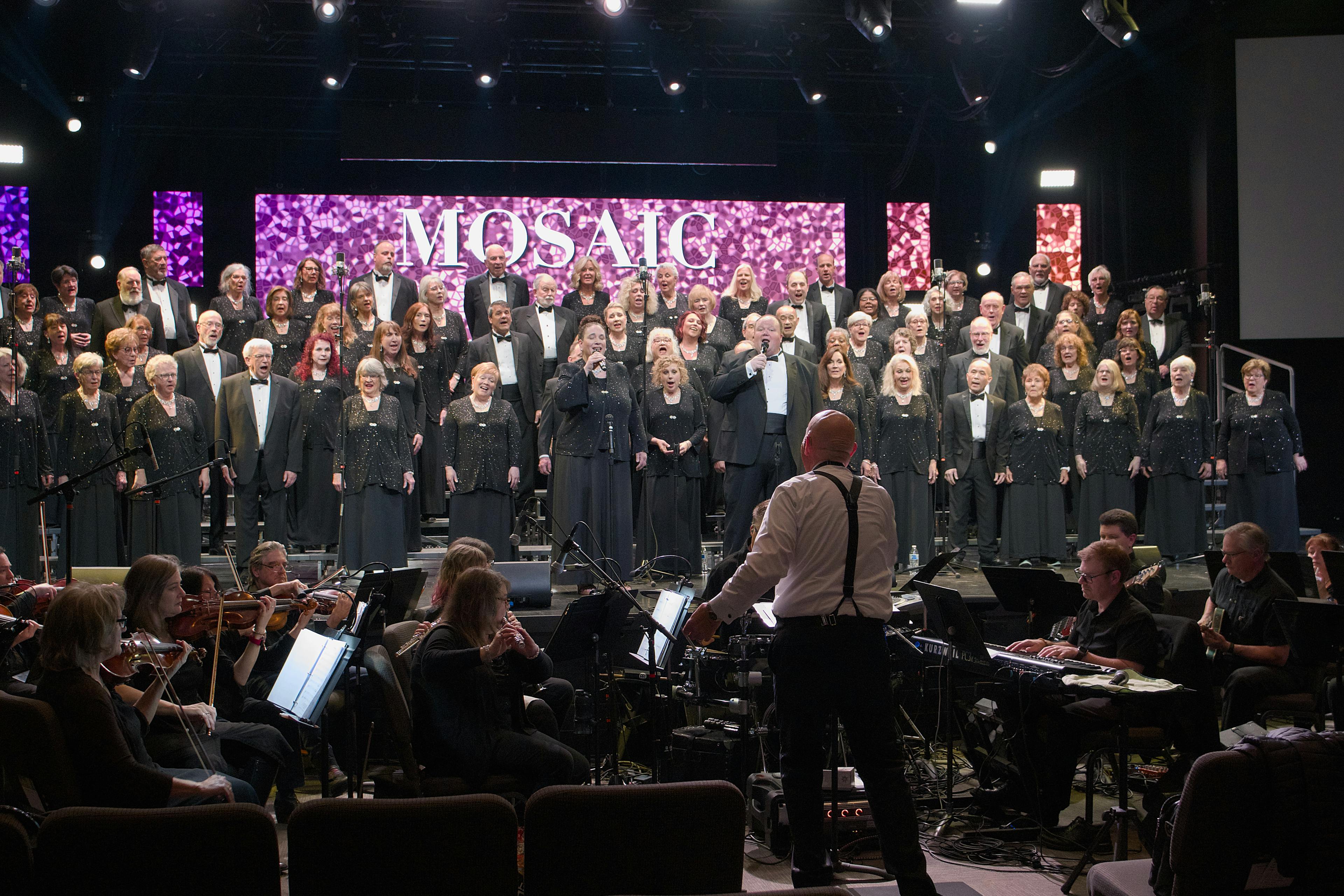 Full choir and orchestra performing on stage