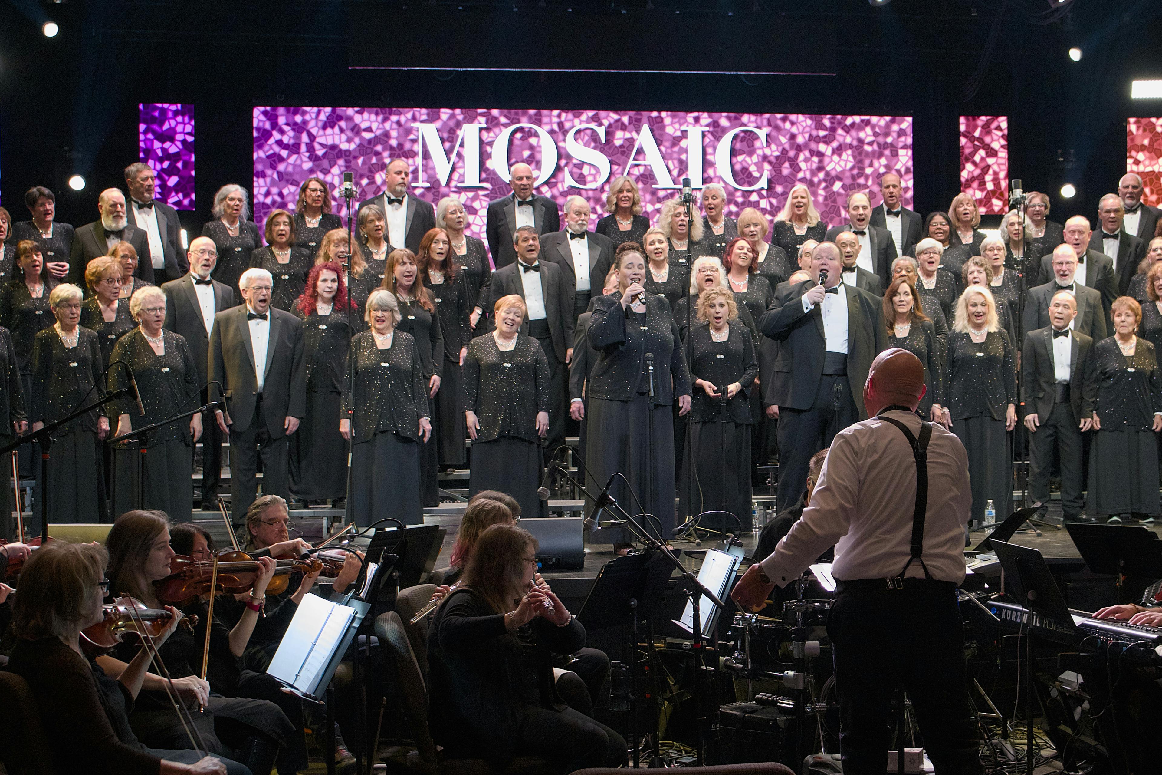 Full choir and orchestra performing on stage