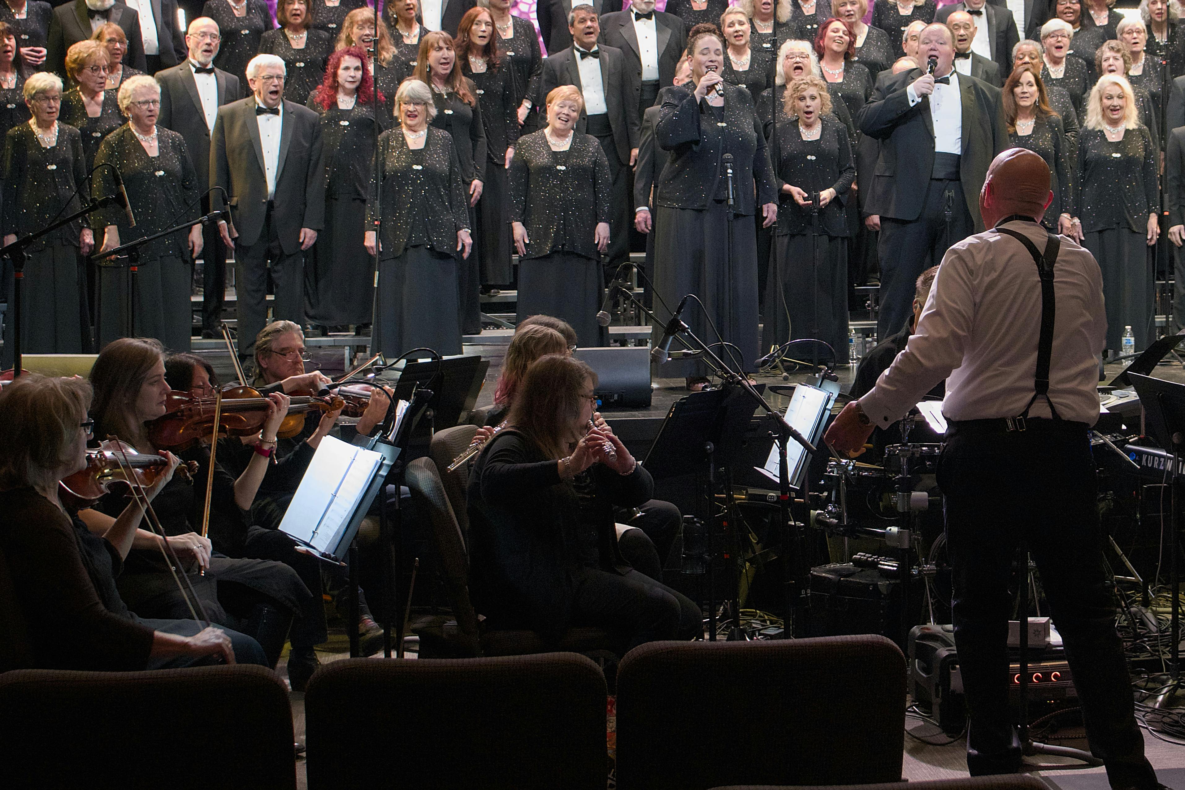 Full choir and orchestra performing on stage