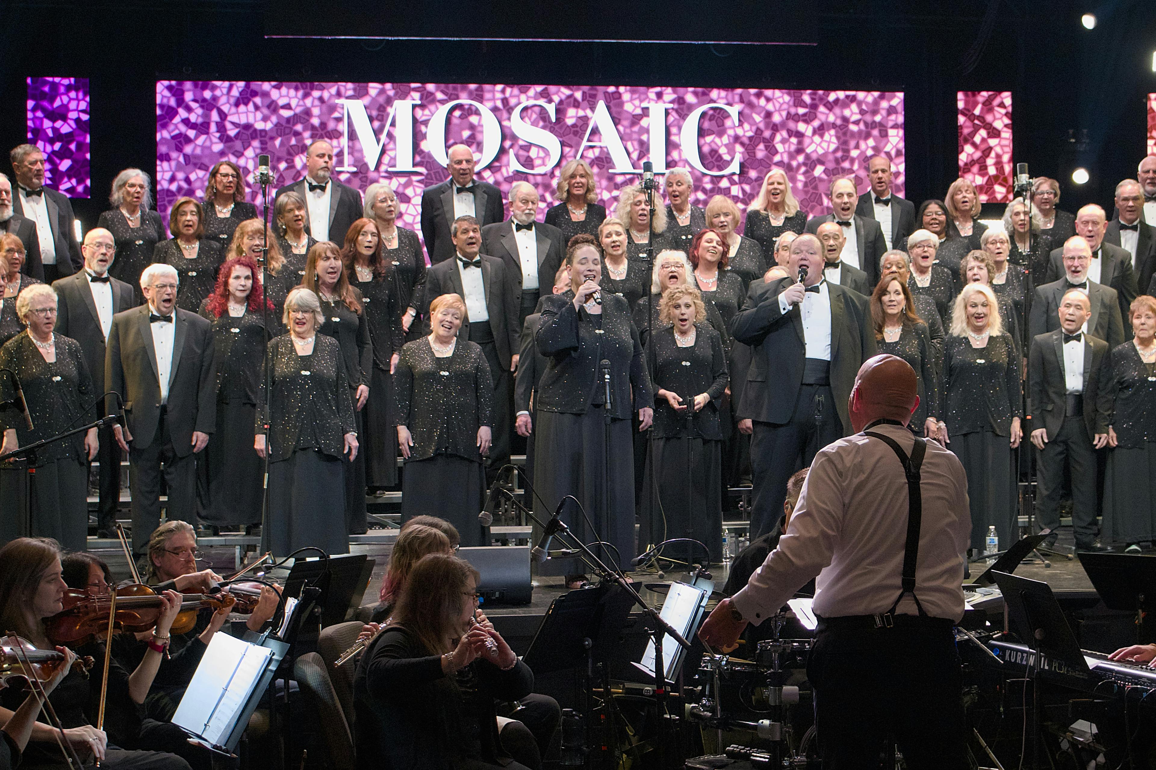 Full choir and orchestra performing on stage