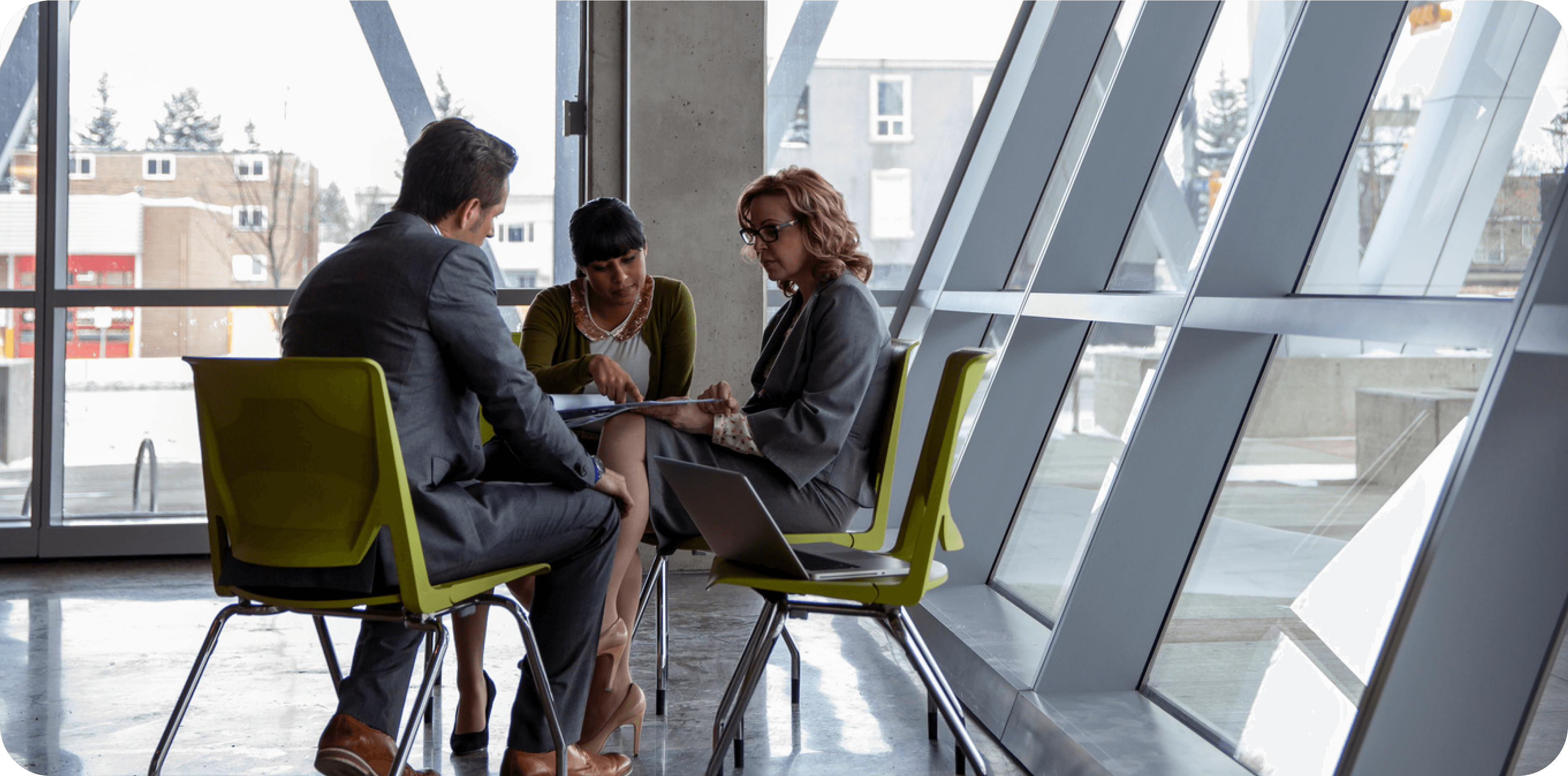 Three people sitting around a table discussing work