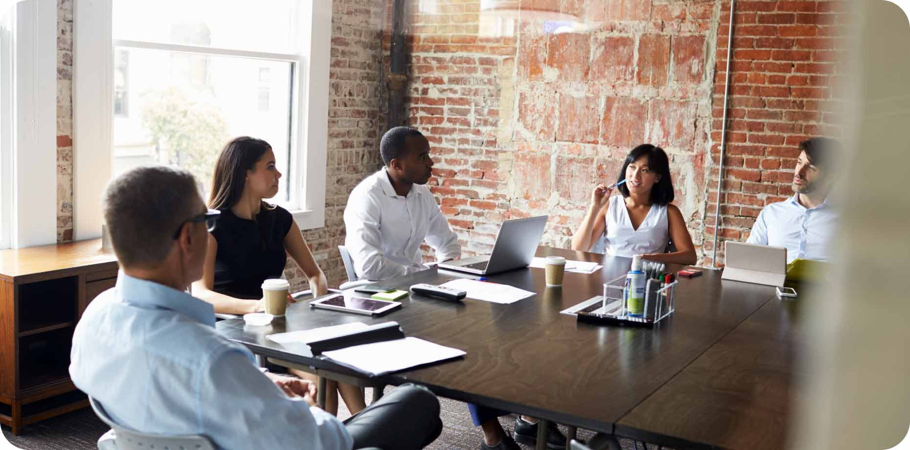 Five people having a business conversation in a conference room