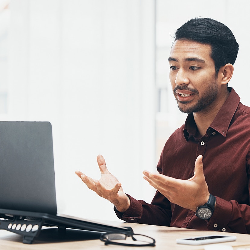 A man speaking in front of a laptop