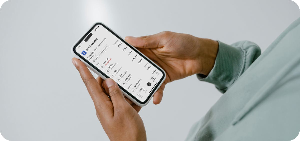 Someone holding a phone with expenses on the screen