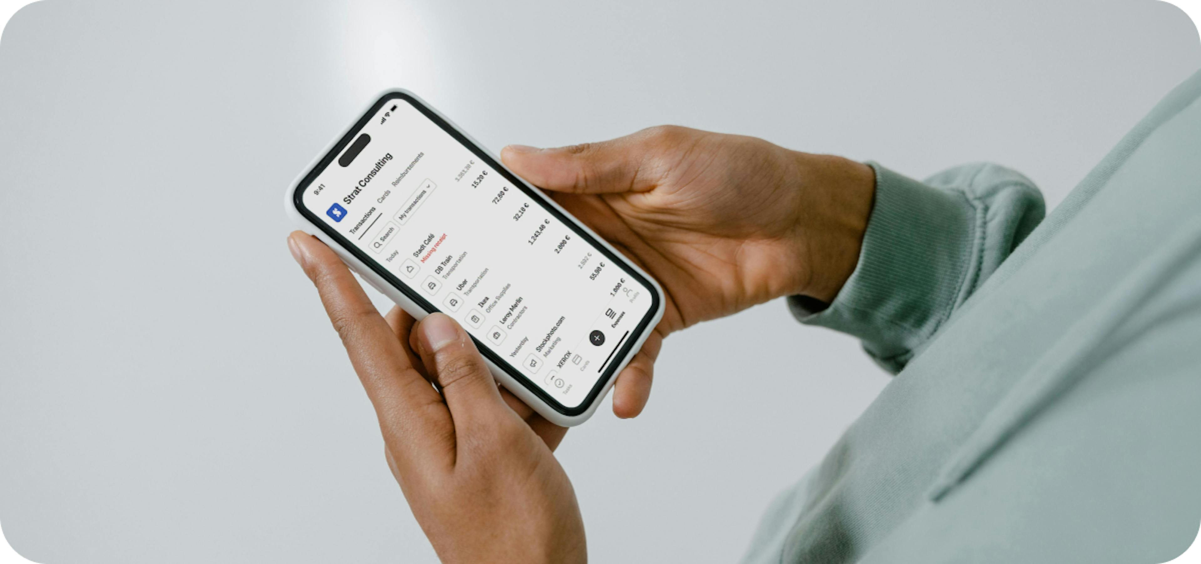 Someone holding a phone with expenses on the screen