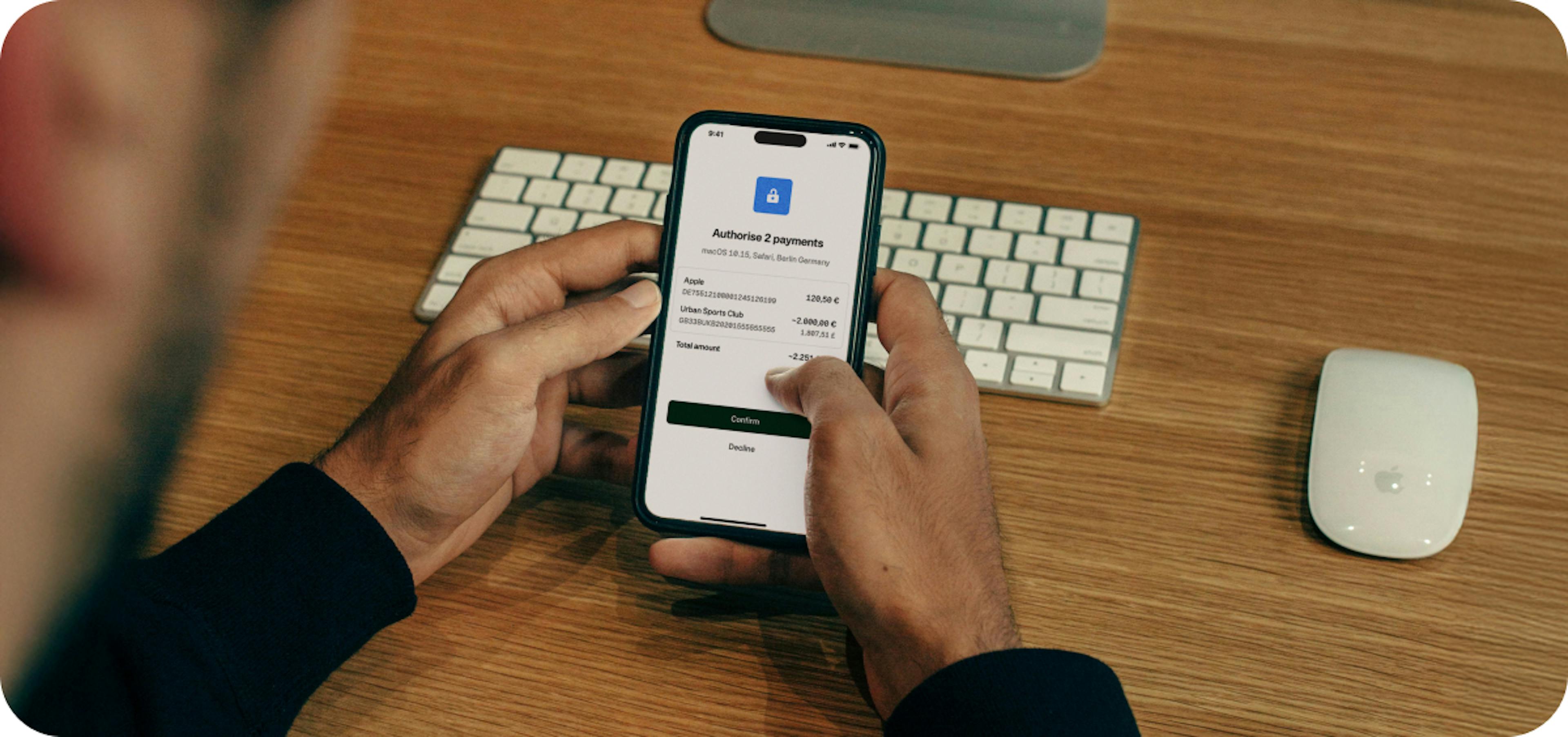 Someone holding a phone on a desk