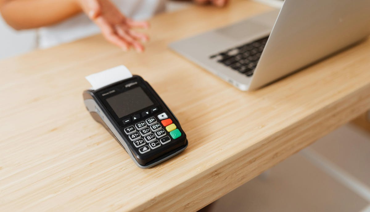A POS terminal in a desk with a laptop