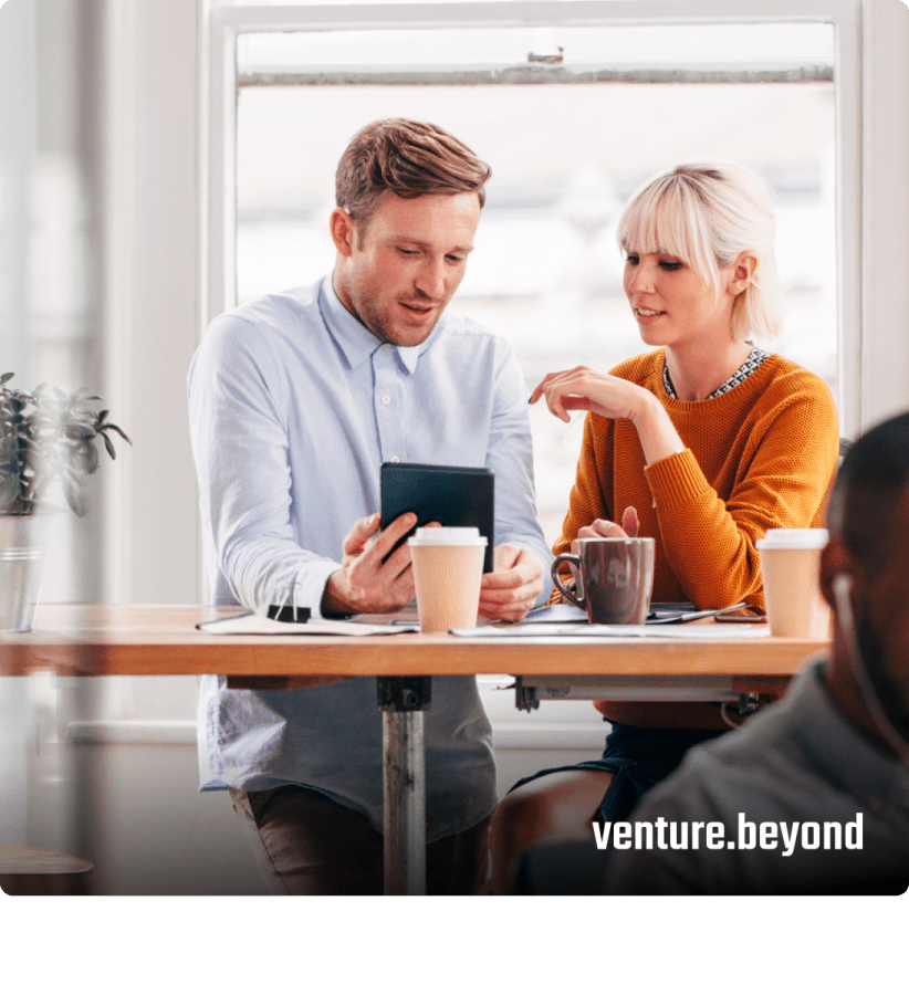 Two people having a work conversation and drinking coffee