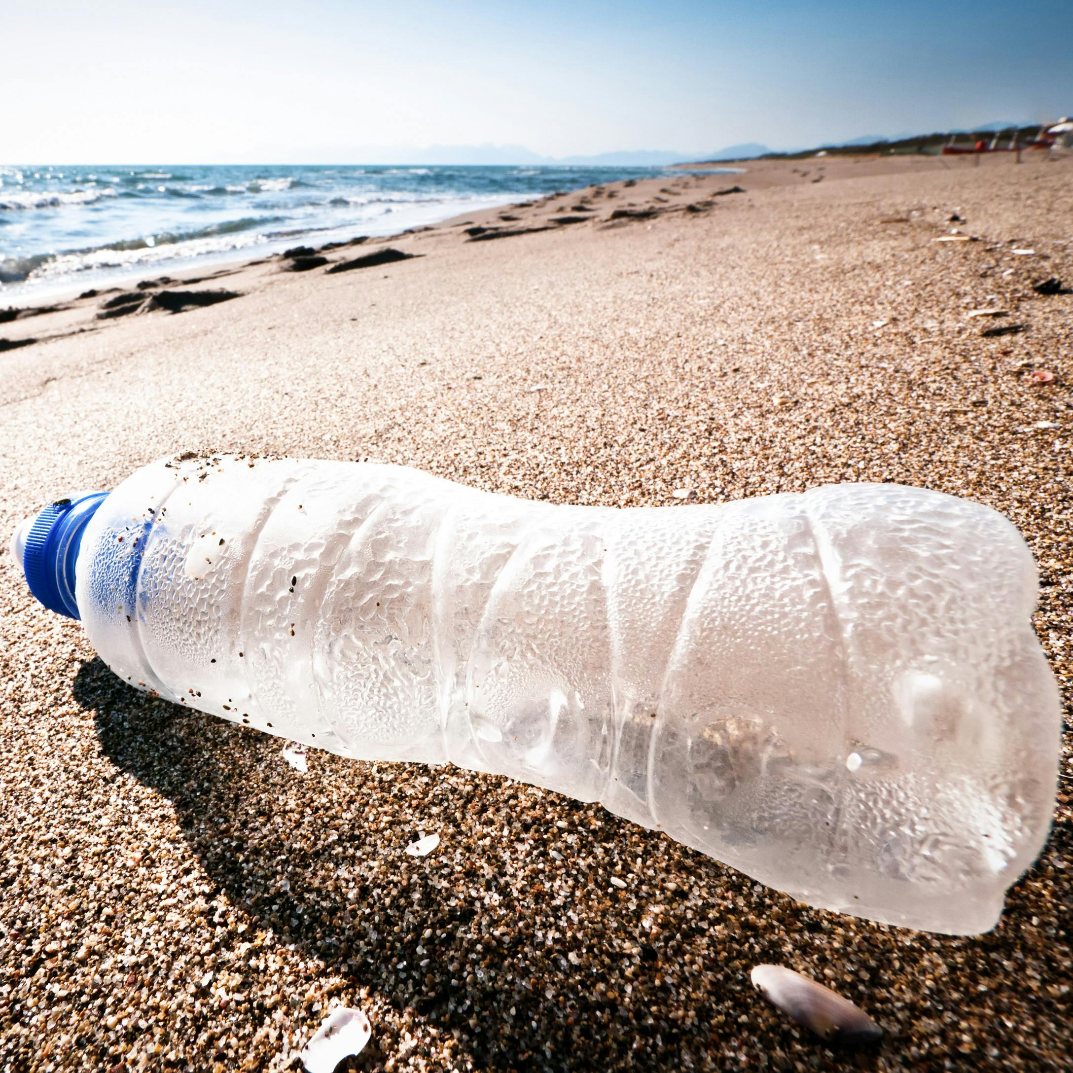 Plastic bottle washed up on beach. Pick it up and trade it for a coffee with the tidal revival app.