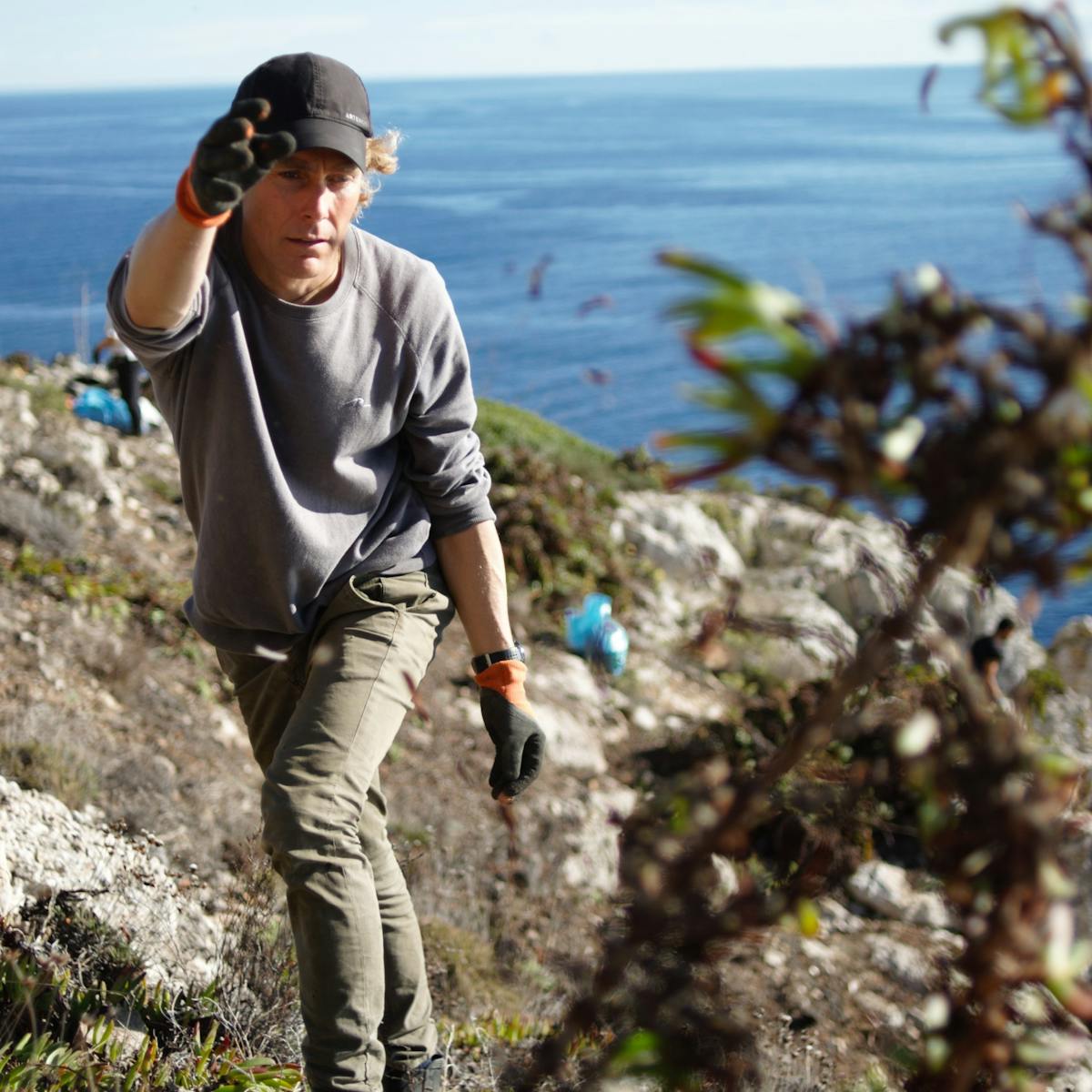Matt, Mossy Earth co-founder, removing the invasive ice plant from the cliff area where we are striving to protect endangered plants.