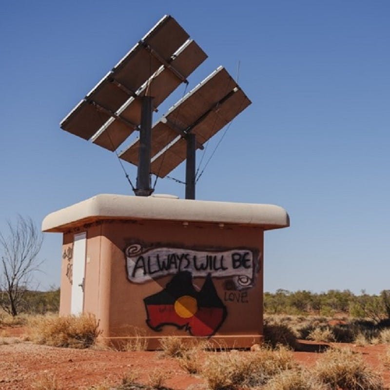 On the wall of a building, an image of the Aboriginal flag takes on Australia's shape.