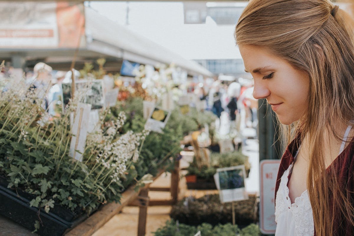 A woman browses in a marketplace of plants. 