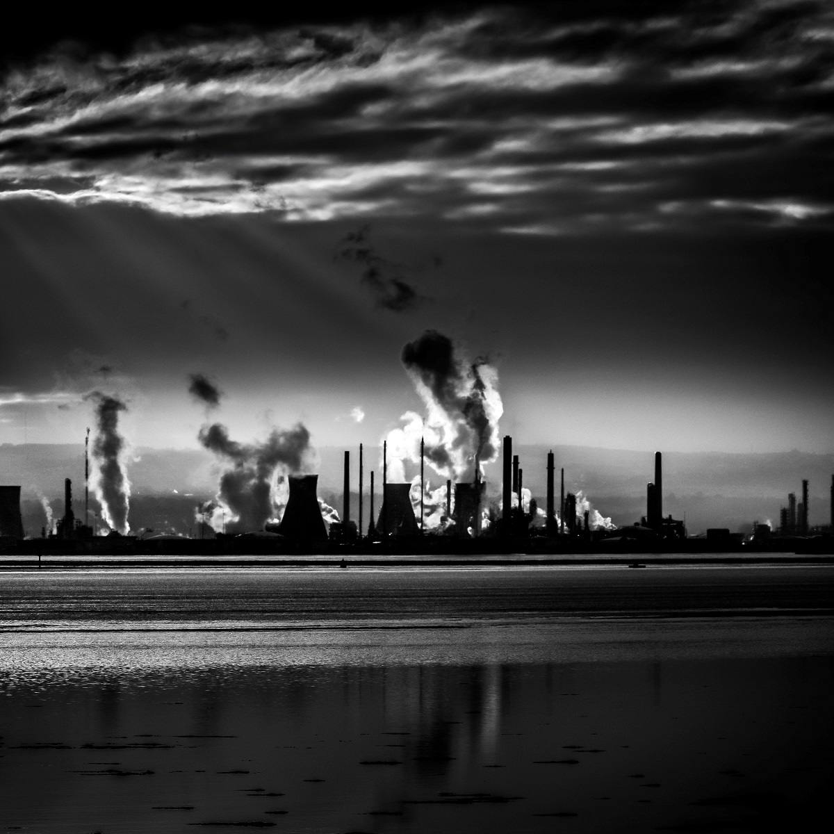 An industrial city on the horizon with a number of factories pumping pollutants into the atmosphere