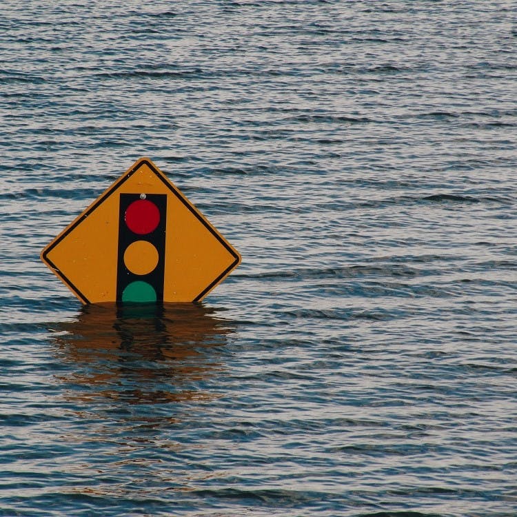 A road sign almost submerged in a flooded area.