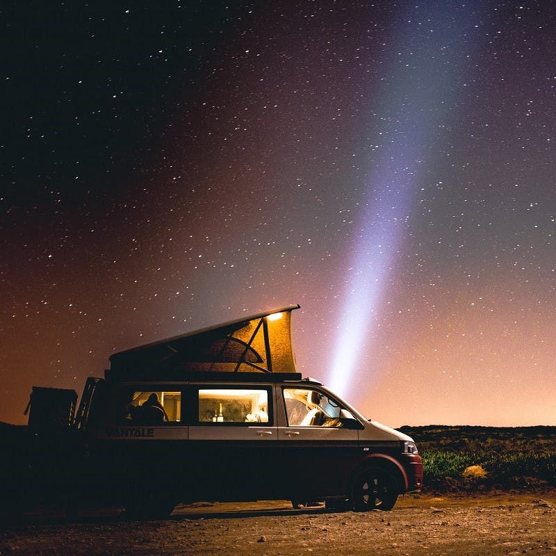 A camper van parked under the stars . Silent star gazing evenings are just one of many advantages to van life. 