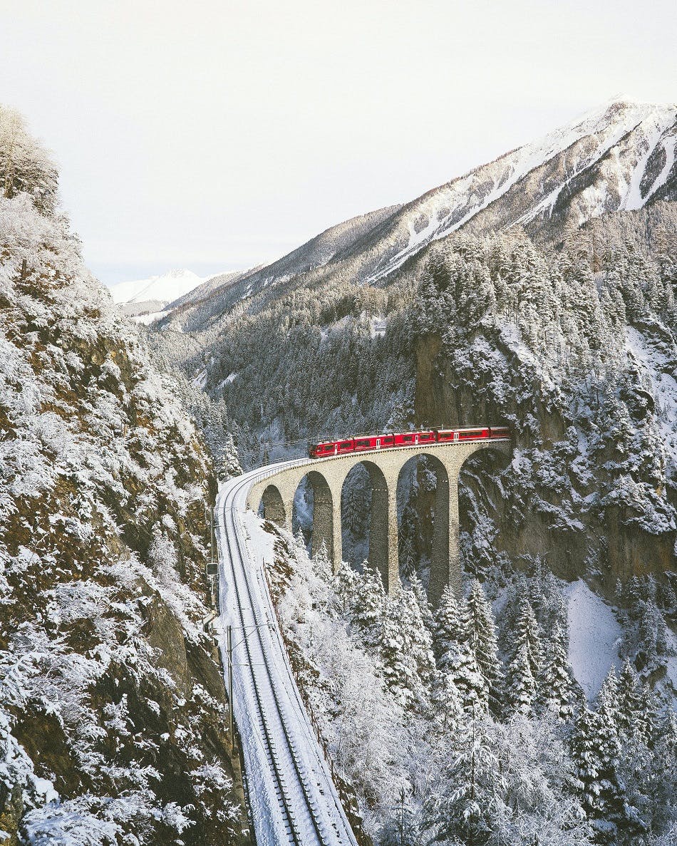 A train passes through a tunnel in the snowy Swiss Alps.