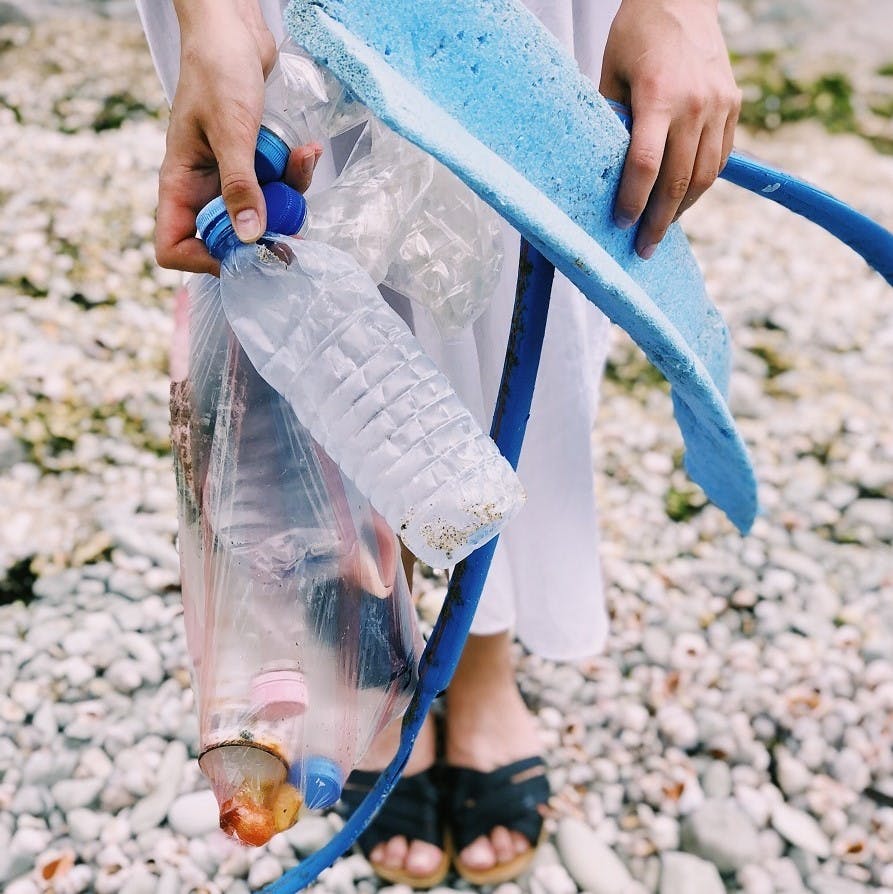 A person showing the litter they have found during an improvised 2 minute beach clean up.