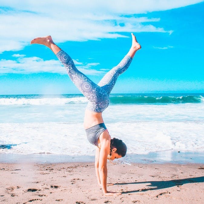 A lady doing a hand stand at the beach alongside her golden retriever dog. Opting for white over red, you will not only be reducing your carbon footprint, but helping to improve your health.