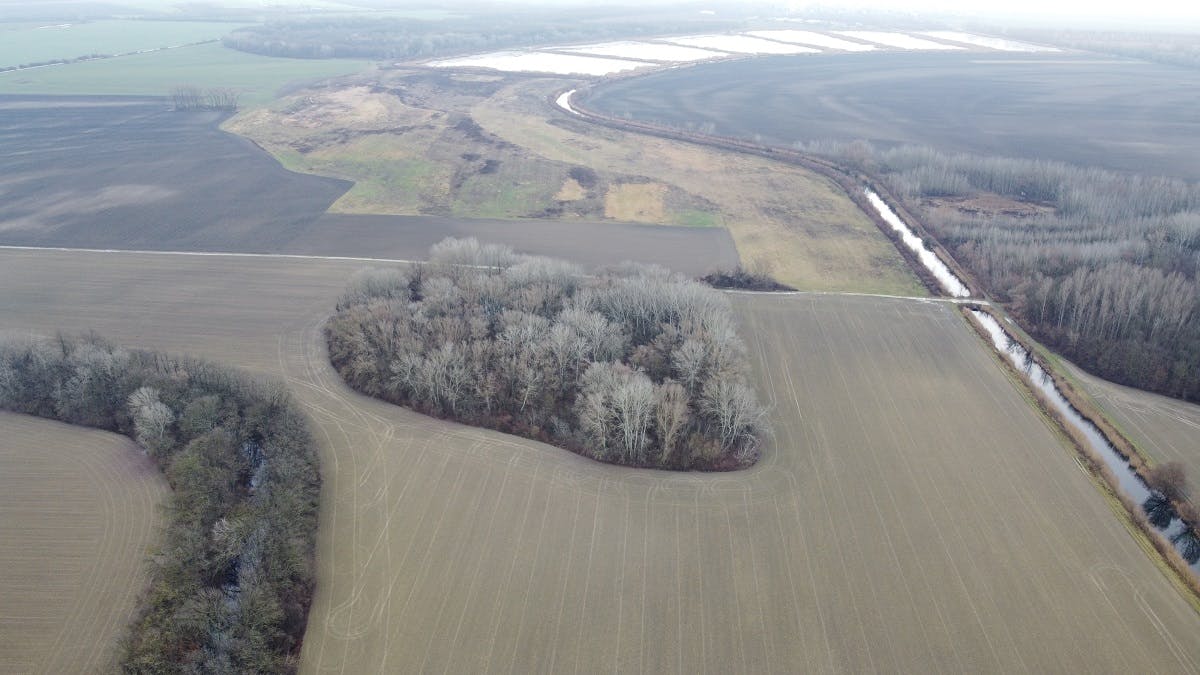The Čiliz Brook in the lefthand corner and surrounding agricultural fields from a drone view.