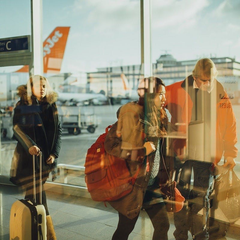 A family walking through an airport corridor. 