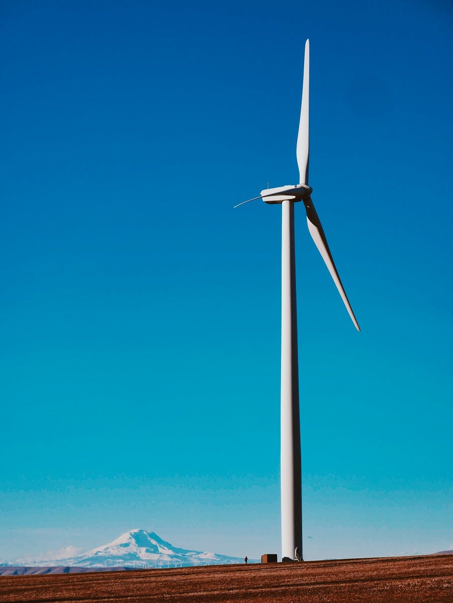 A wind turbine in the mountains. Renewable energies such as wind energy is a prominent strategy in the Paris Agreement and in the fight against climate change.  