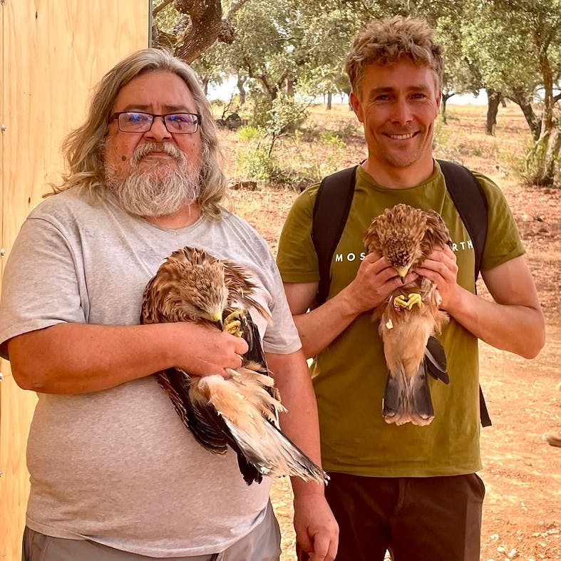 Matt Davis, co-founder of Mossy Earth, holding a red kite with a project partner.