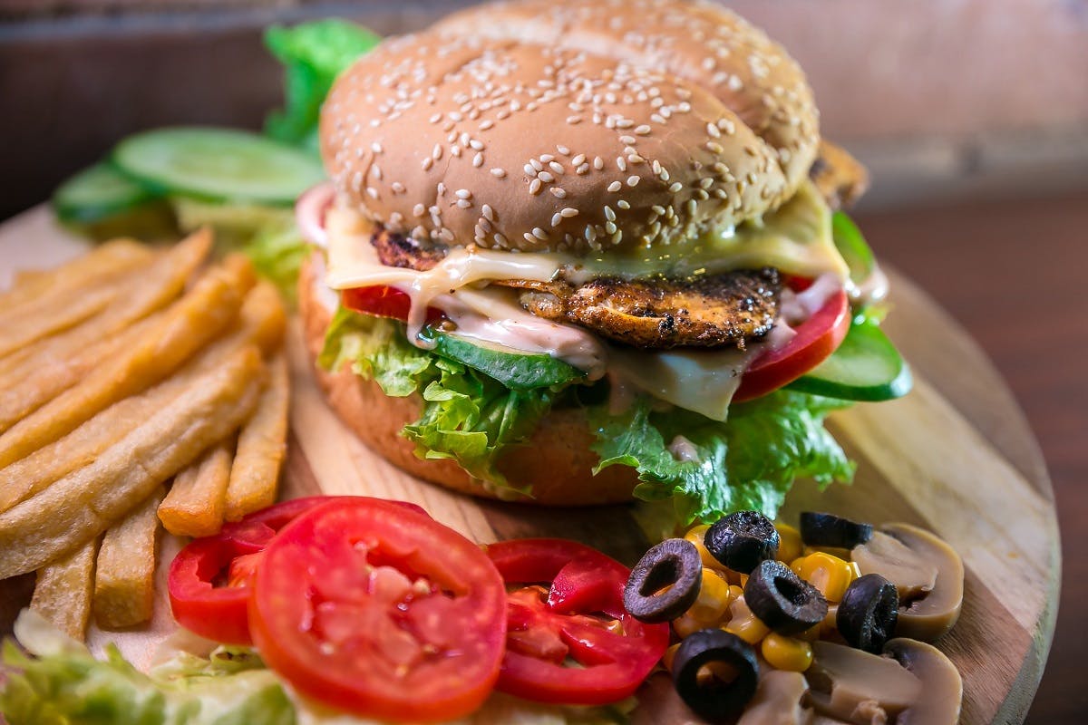 A chicken burger with salad and fries