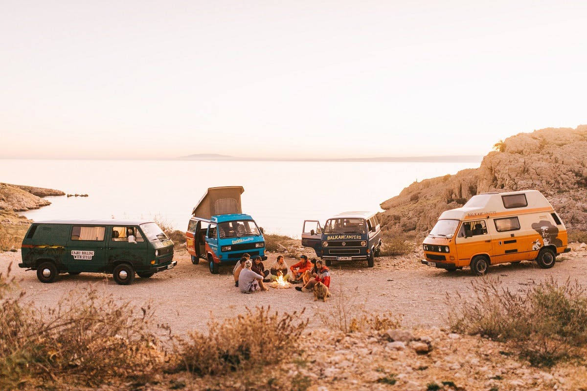 Four camper vans parked up by the beach for a camp fire. #vanlife