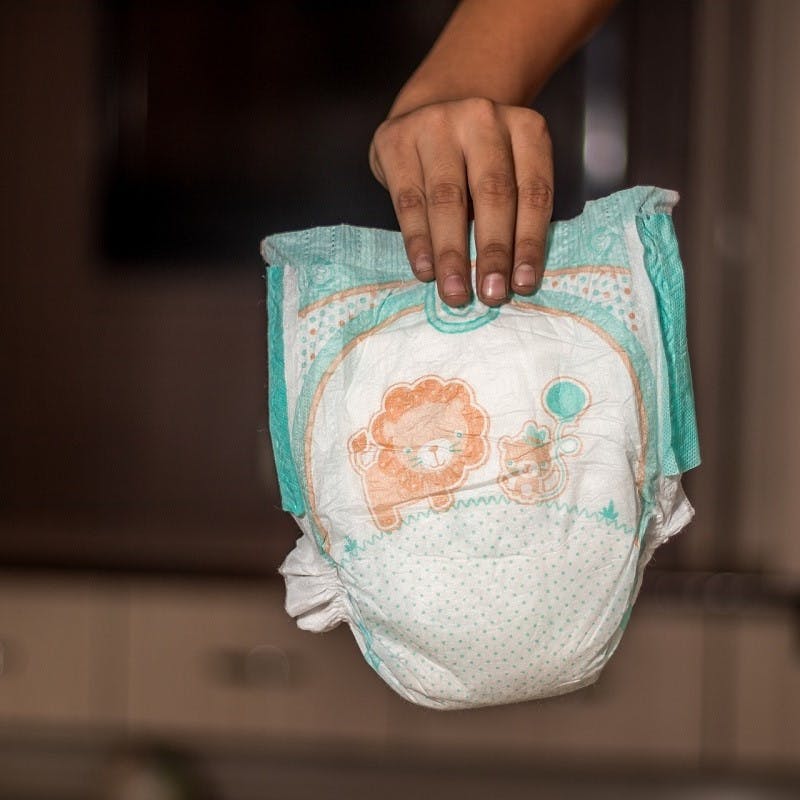 A disposable nappy being put out in the trash. When you look at the number of nappies in landfill, there is no contest in the reusable nappies vs disposable debate. 