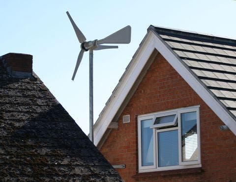 A small wind turbine installed on a residential home to take advantage of free and renewable wind energy.