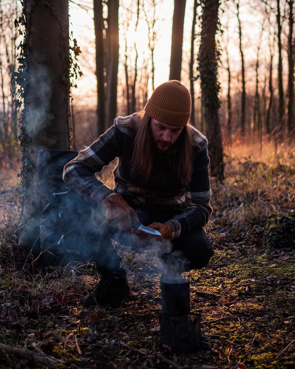 A man wild food foraging in a forest with a penknife 