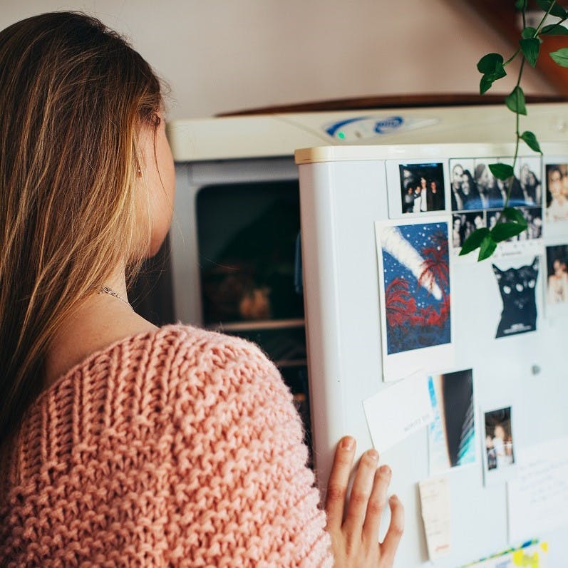 A lady checking the content of her fridge, a common occurrence when working from home.