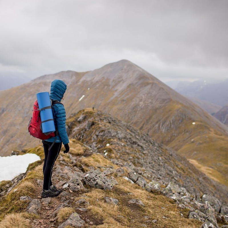 A hiker standing at viewpoint on a Scottish mountain.