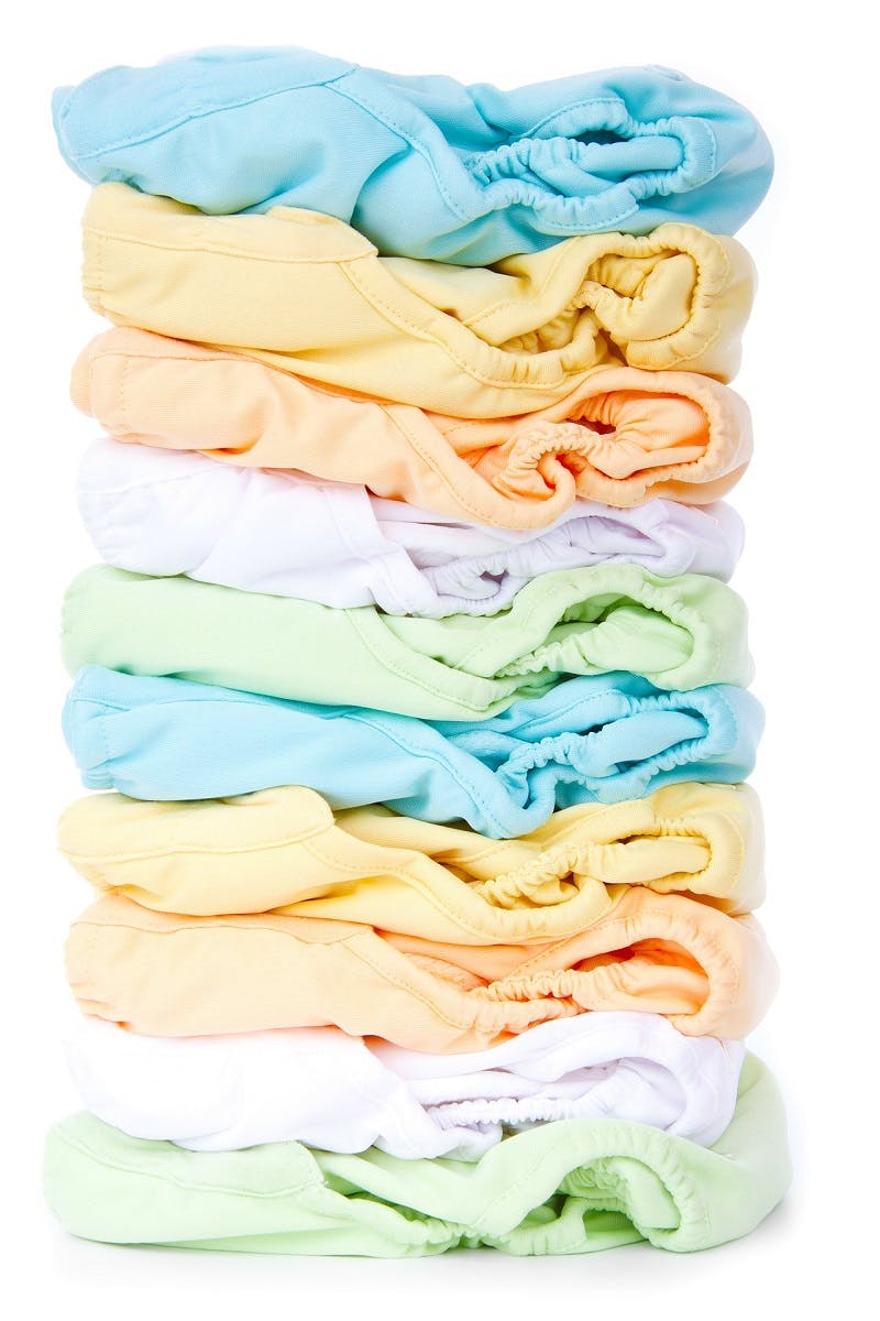 A pile of reusable washable cloth nappies in a variety of colours
