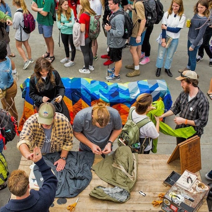 A group of people repairing, reusing and recycling clothing at a Patagonia Worn Wear event