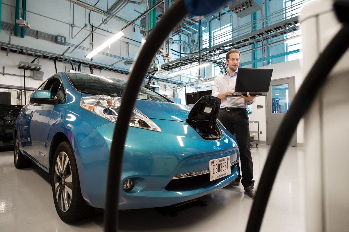 An electric blue electric car being manufactured. The emissions factors of manufacture and battery disposal vs lifetime use of an electric car is a heatedly debated topic regarding electric cars pros and cons.
