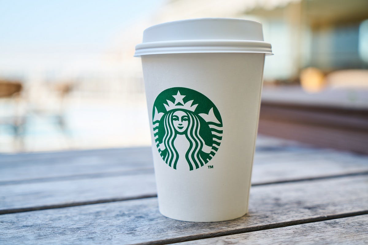 A take away Starbucks coffee cup on park bench. By now we should all be refusing single use plastics like these.