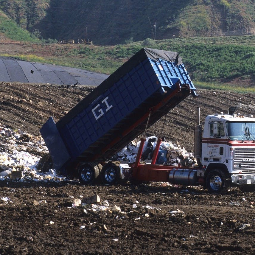 A truck dumping waste at a landfill site