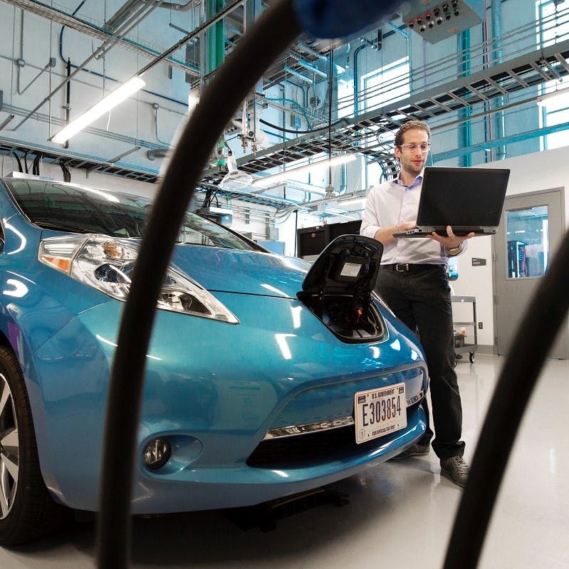 An electric blue electric car being manufactured. The emissions factors of manufacture and battery disposal vs lifetime use of an electric car is a heatedly debated topic regarding electric cars pros and cons. 