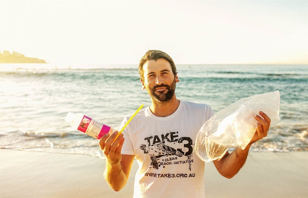 A man collecting litter from his local beach. 