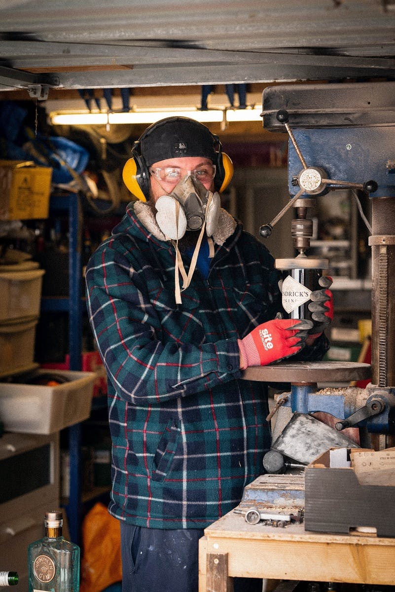 A man upcycling an old gin bottle. Upcycling is a key preponement of a circular economy 