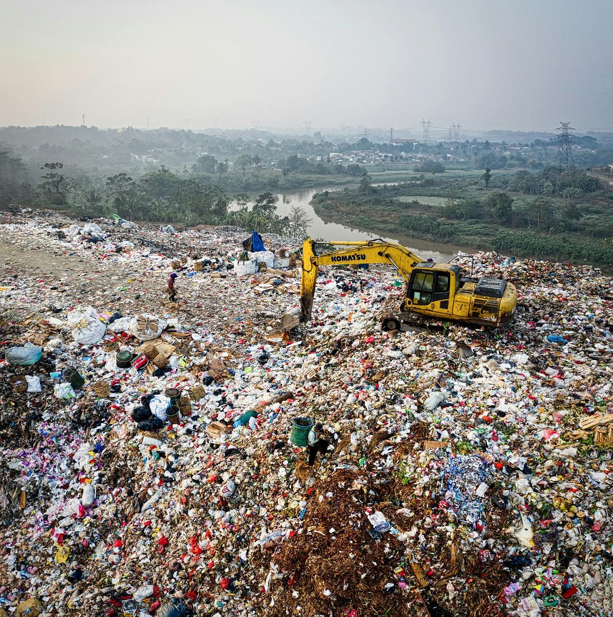 An excavator moving waste at a landfill site.  Let's keep clothing out of landfill by choosing to repair, reuse, recycle our garments.