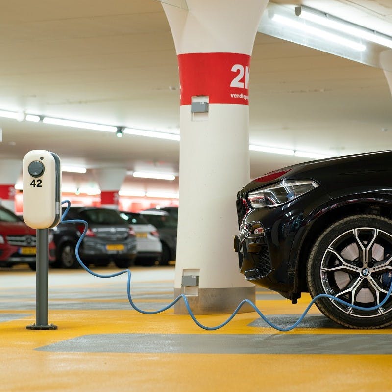 An electric company car being charged at work in an underground carpark. 
