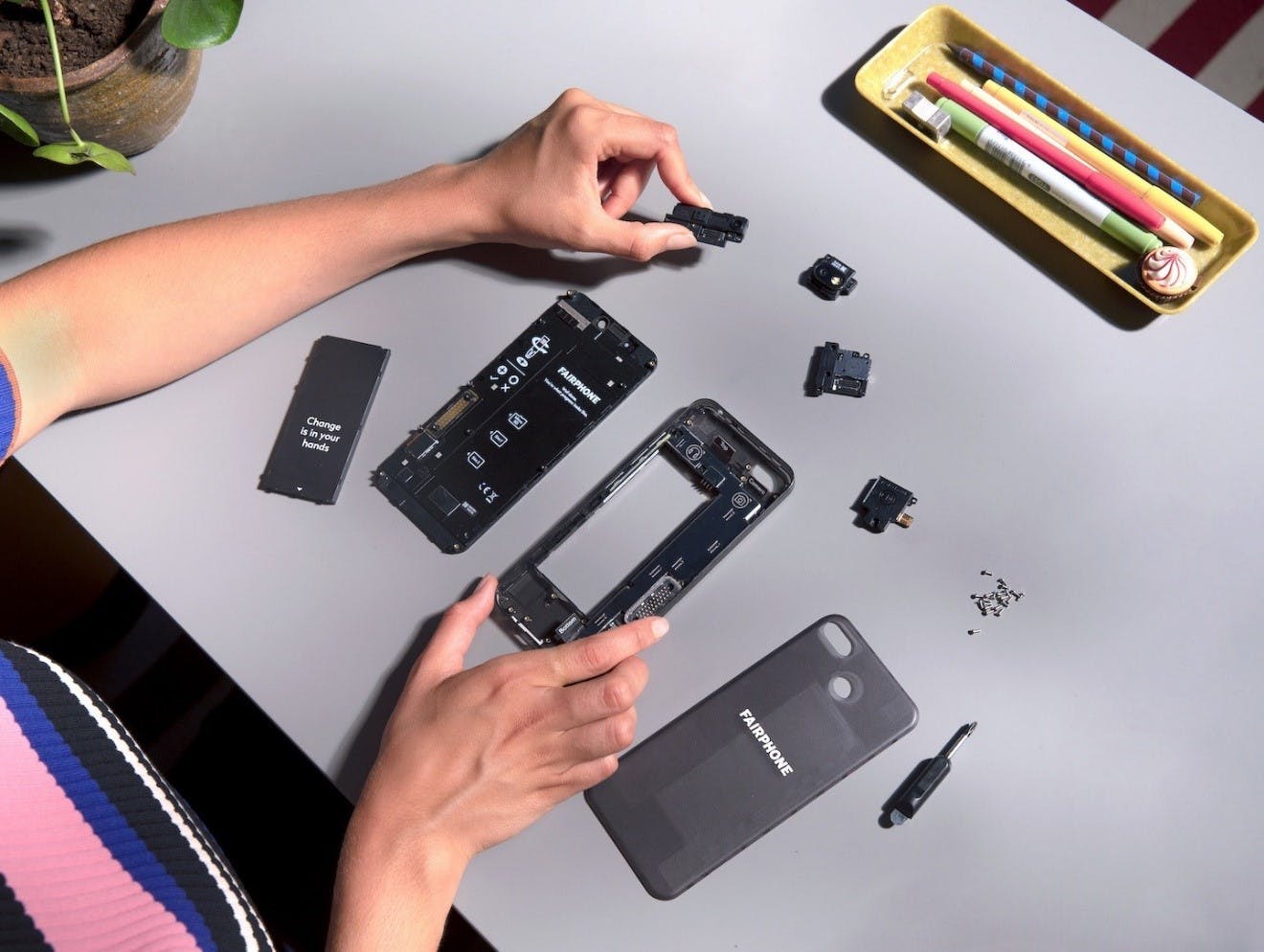 A person dismantling their sustainable and ethical smartphone by Fairphone.