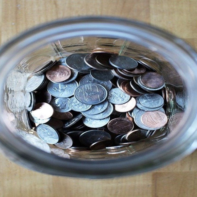 Birds-eye-view of a glass jar of coins. Eco homes offer great savings for the environment and your piggybank.