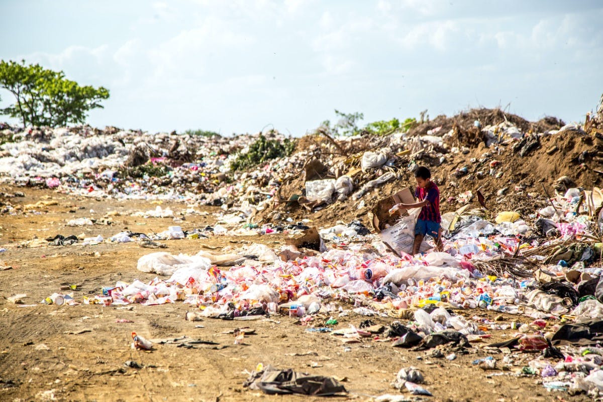 Child walking through landfill